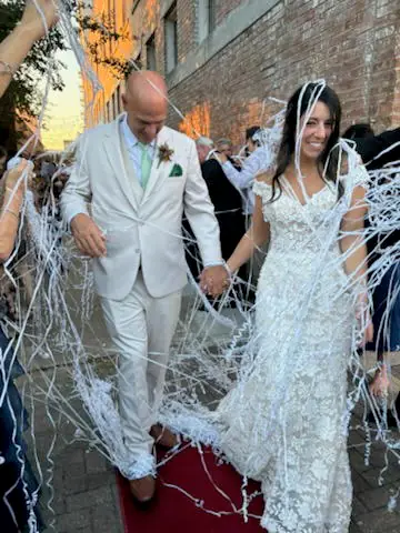 A couple laughing in a shower of confetti