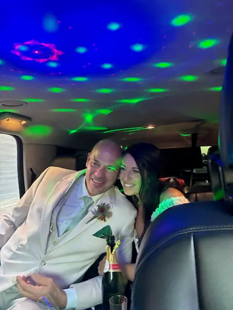 A couple seated in the car with party lights glowing