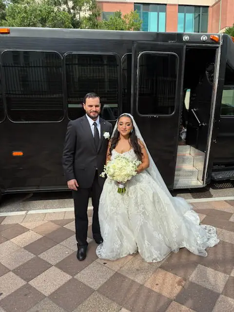 Bride and groom standing beside the coach